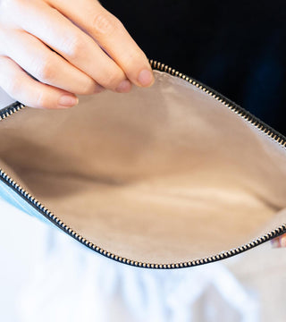 A woman showing the inside soft lining of the Starburst Nappa Leather Large Clutch